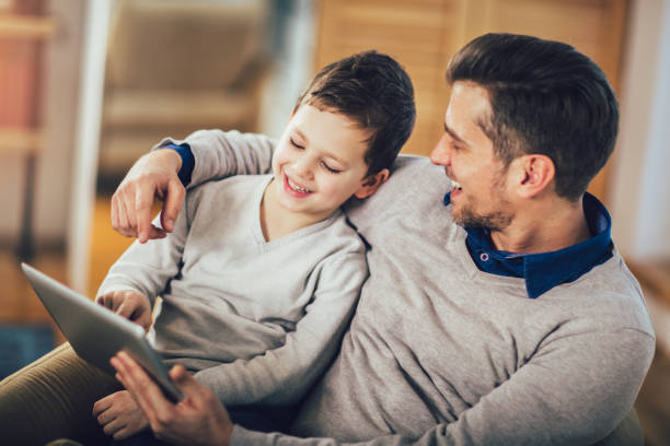 istock Father and son playing on a tablet at home, having fun 1212132691