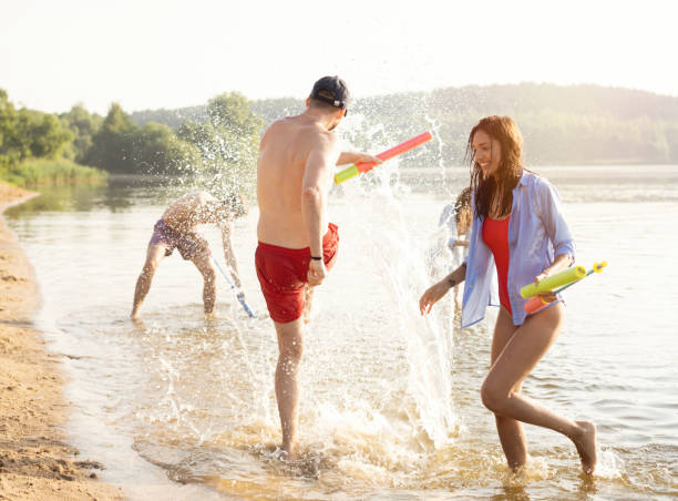 istock Happy people with water guns have fun on the beach 1212135879