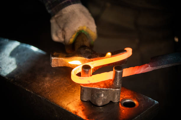 istock A man blacksmith making a unique handle for the knife - bending the metal 1212135968
