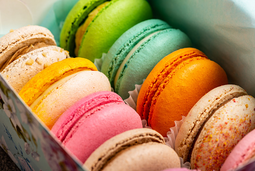 Multi-colored macaroons with different tastes in a gift box. Macro