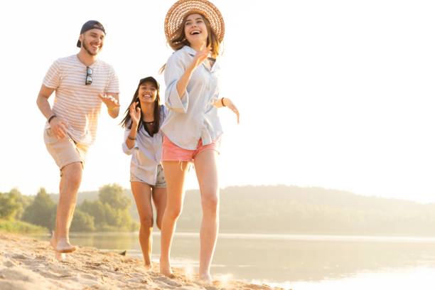 istock Group of friends having fun running down the beach 1212136132