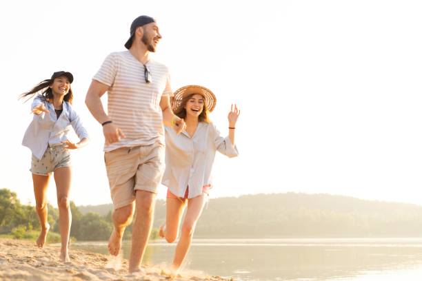 istock Group of friends having fun running down the beach 1212136133