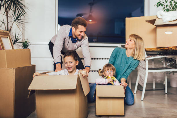 istock Happy family moving home with boxes around 1212137001