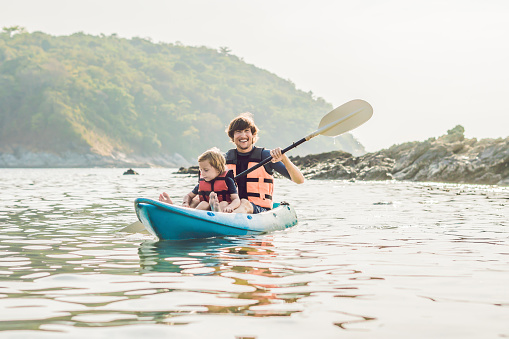 Father and son kayaking at tropical ocean. Travel and activaties with children concept.