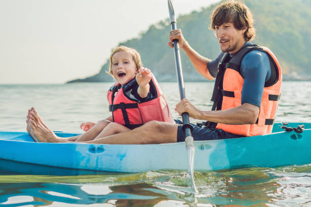 istock Father and son kayaking at tropical ocean. 1212138956