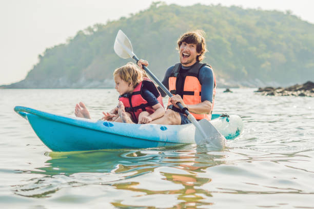 istock Father and son kayaking at tropical ocean. 1212138958