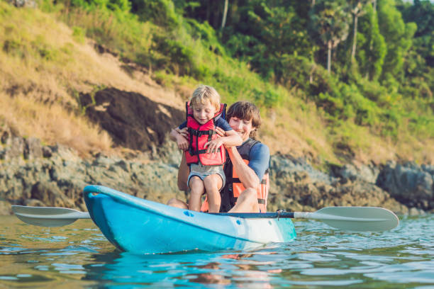 istock Father and son kayaking at tropical ocean. 1212138980