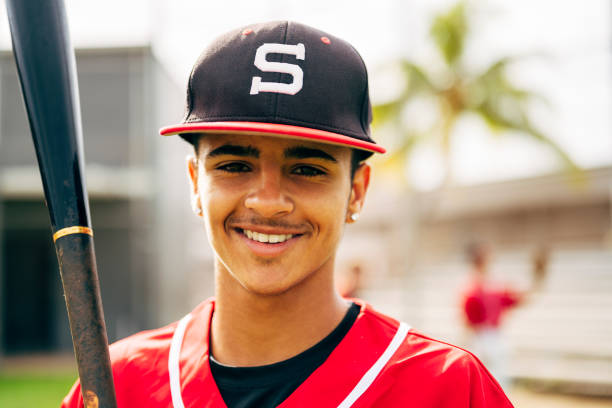 istock Portrait of smiling young Hispanic baseball player with bat 1212139012