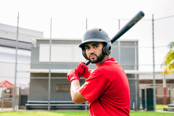 Bearded Hispanic baseball player outdoors in batting stance Close-up of young bearded Hispanic baseball player standing outdoors in batting stance and waiting for the pitch. high school baseball stock pictures, royalty-free photos & images