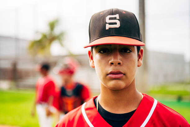 istock Young Hispanic baseball player on the field with teammates 1212139017