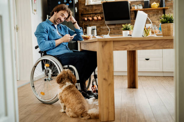 glücklicher behinderter geschäftsmann mit dem handy, während er eine pause von der arbeit zu hause. - people business dog owner stock-fotos und bilder