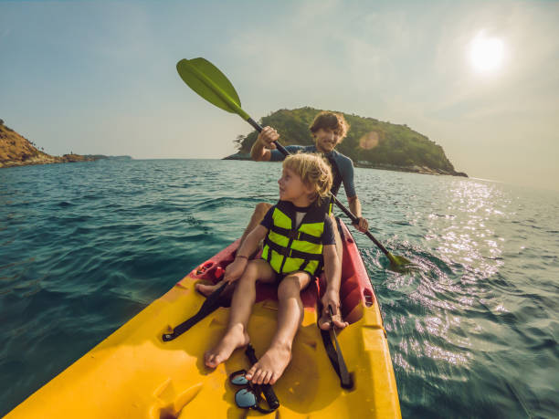istock Father and son kayaking at tropical ocean 1212140992