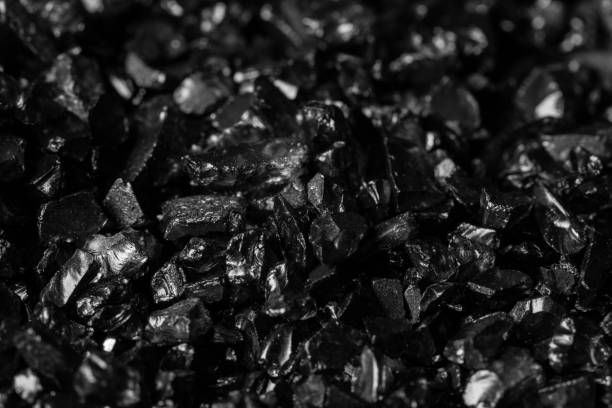 Background of black sand. Fine glass chips. Macro shooting.