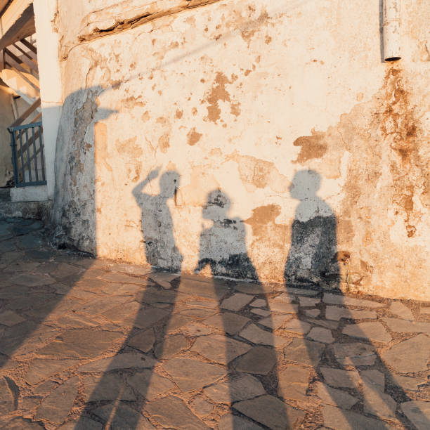 istock Long shadows of young men on medieval village wall 1212145453