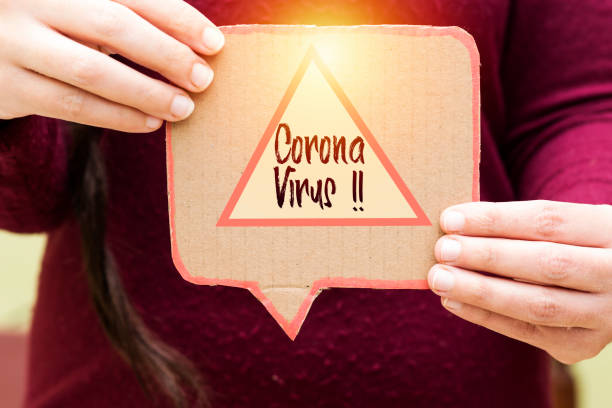 istock closeup hand holding carton speech bubble with warning coronavirus sign 1212148984