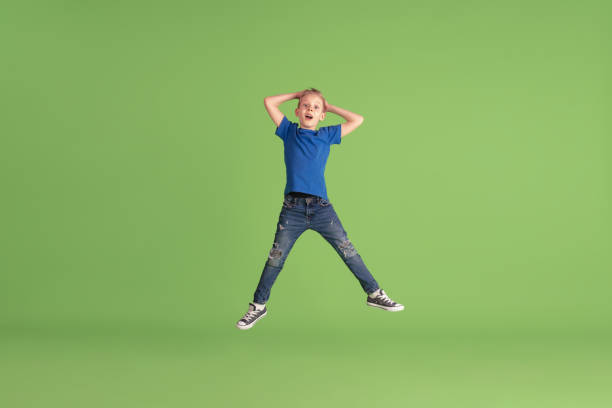 istock Happy boy playing and having fun on green studio background, emotions 1212149052