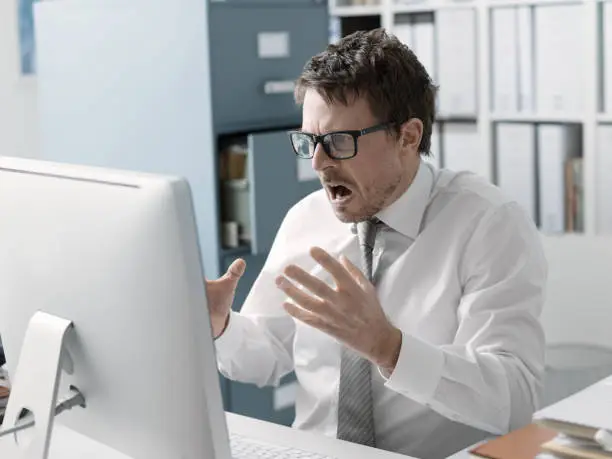 Photo of Angry business executive shouting at the computer