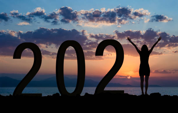 新年2021年を祝いながら丘の上で楽しむ女性 - sunrise hill sea sun ストックフォトと画像