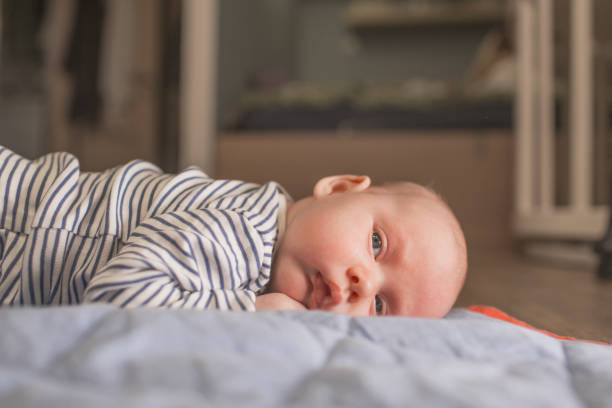 istock Baby boy lying on front in living room 1212153554