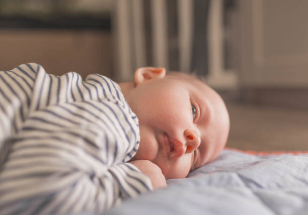 istock Baby boy lying on front in living room 1212153574