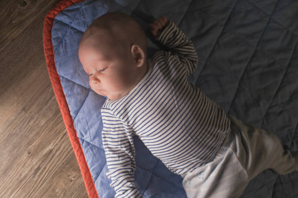 istock Baby boy lying on front in living room 1212153616