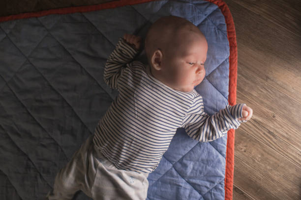 istock Baby boy lying on front in living room 1212154173