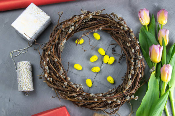 istock Easter wreath, yellow Easter eggs around tulips, gifts and wrapping paper 1212155407