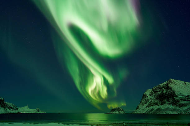 hauklandbeach, islas lofoten / norway - marzo el 6 de marzo de 2019: la aurora boreal (otro nombre es aurora boreal) moviéndose sobre la isla de tá del fiordo en hauklandbeach - magnetosphere fotografías e imágenes de stock