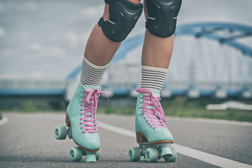 Woman rollerskater wearing knee protector pads on her leg