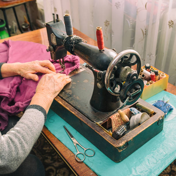 istock Woman sews on an old sewing machine 1212160466