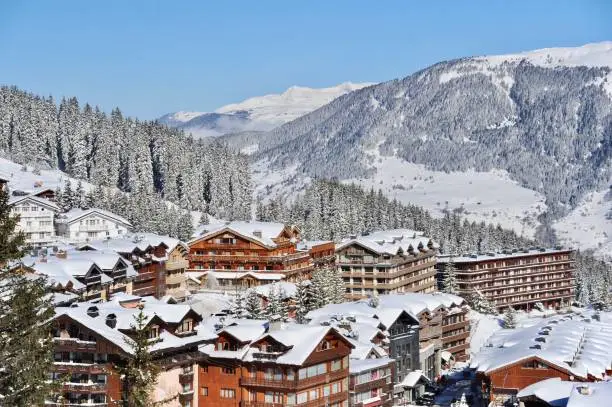 Ski resort village with wood houses and snowy mountains