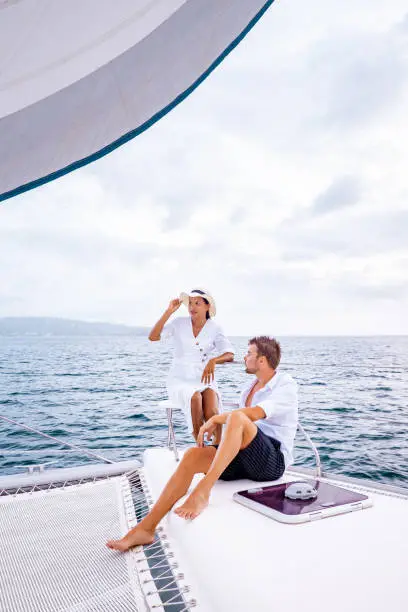 Photo of St Lucia, couple men and woman watching sunset from sailing boat in the Caribbean sea near Saint Lucia or St Lucia