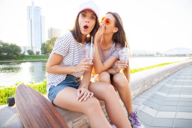 Two pretty cuter teenagers shares secrets, gossip. Surprise face, emotions, Best friends wearing stylish outfit. Bright summer colors Two pretty cuter teenagers shares secrets, gossip. Surprise face, emotions, Best friends wearing stylish outfit. Bright summer colors. slander stock pictures, royalty-free photos & images