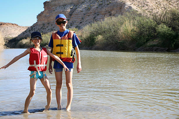 hermano y hermana jugando en río - rio grande life jacket big bend national park little boys fotografías e imágenes de stock
