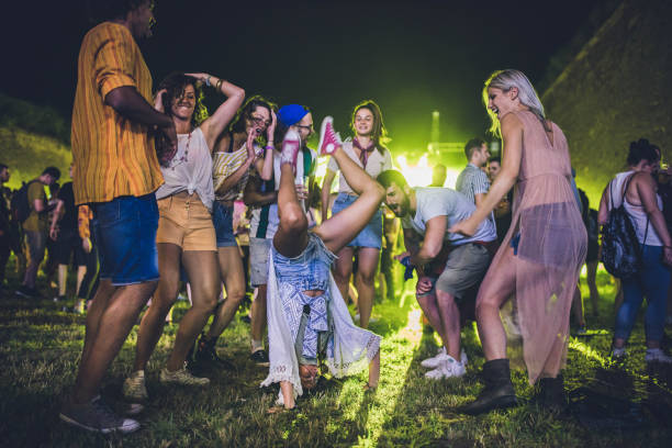 istock Large group of cheerful people having fun while dancing on music concert by night. 1212168103