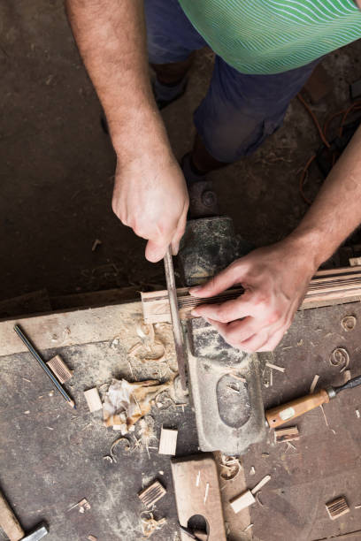 istock Male carpenter working on old wood in a retro vintage workshop. 1212168751