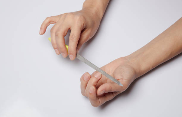 istock Nail file in womens hands isolated 1212171570