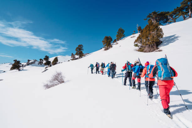 squadra di alpinismo in montagna che cammina di fila fino alla vetta della montagna d'alta quota in inverno - turkey extreme terrain snow nature foto e immagini stock