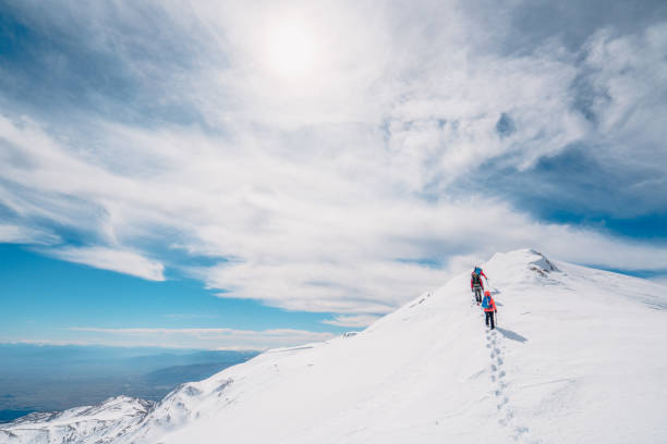 squadra di alpinismo in montagna che cammina in fila in alta quota in inverno - turkey extreme terrain snow nature foto e immagini stock