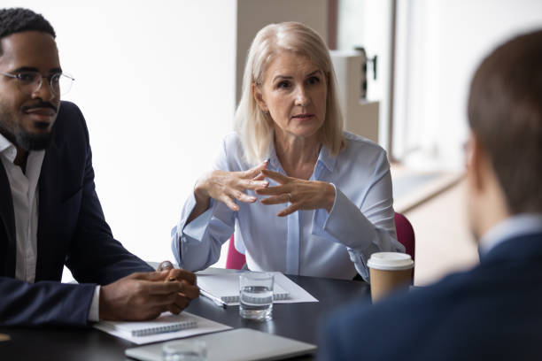 istock Diverse businesspeople discuss project at meeting together 1212172523