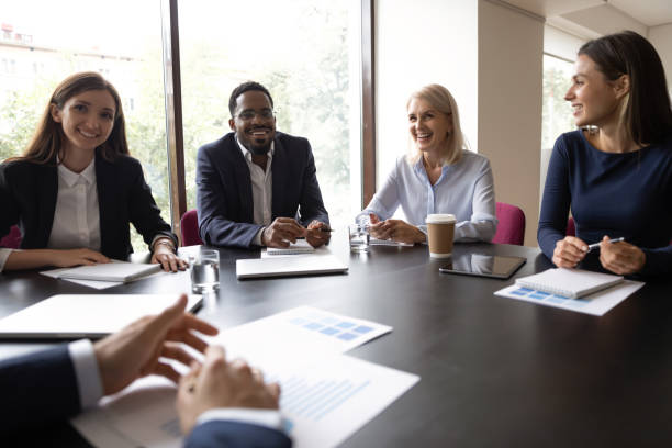 istock Smiling diverse colleagues laugh discussing ideas at meeting 1212172525