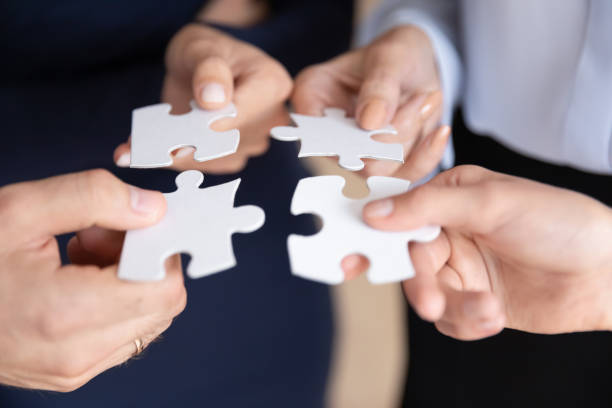 istock Close up of businesspeople assemble jigsaw puzzle at work 1212172575