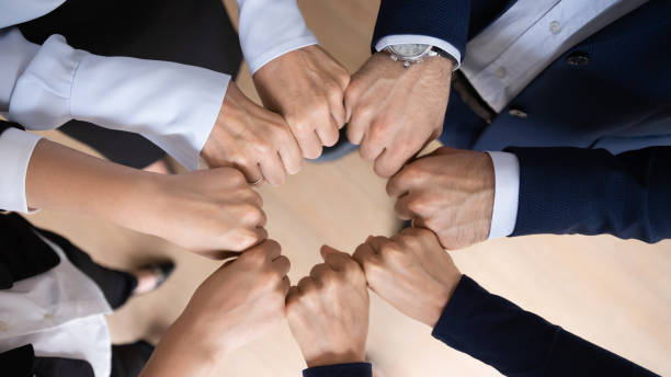 istock Diverse businesspeople join hands engaged in teambuilding together 1212172579