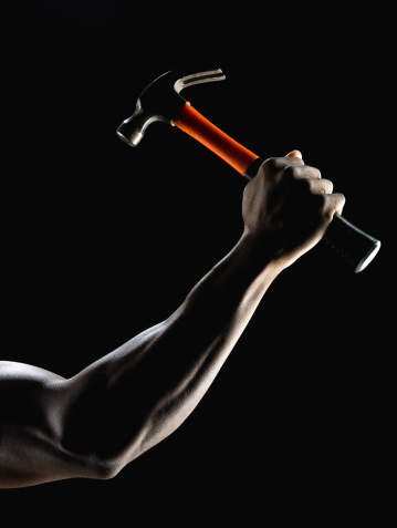 Muscle arm holding a hammer on black background (this picture has been taken with a Hasselblad H3D II 31 megapixels camera)