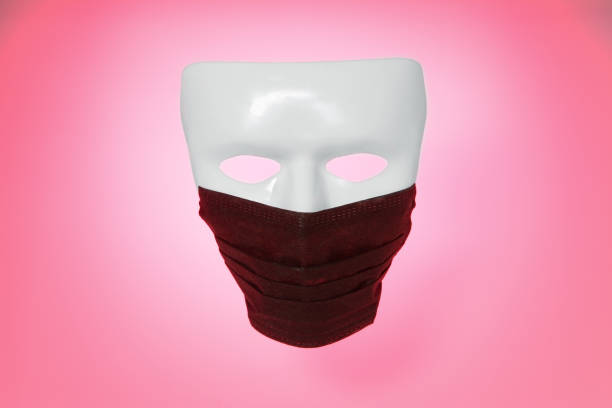 istock White death mask in black medical protective mask, on red gradient background. Death from dangerous COVID-19 concept, 2019-nKoV or Covid-19. 1212174002