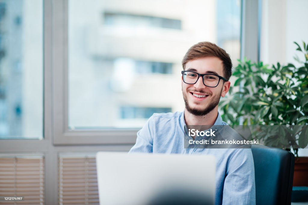 Young businessman in office Young businessman in office working on laptop Office Stock Photo