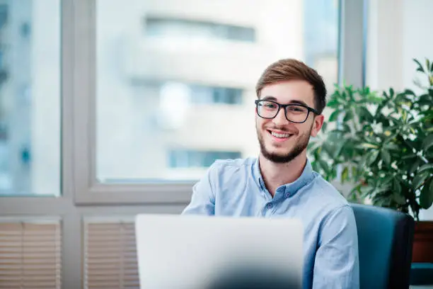 Young businessman in office working on laptop