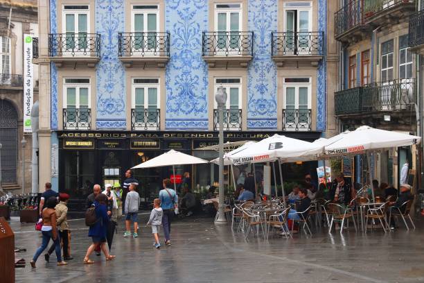Tourists visit old town shopping street in Porto, Portugal. Porto is the 2nd largest city in Portugal. Its old town is a UNESCO World Heritage Site.