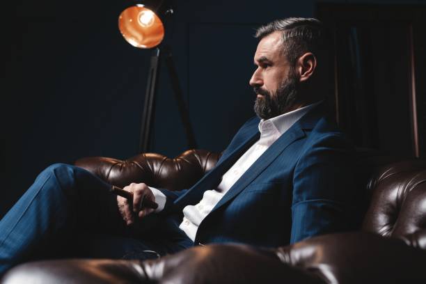 istock Attractive man with cigar and a glass whiskey 1212176450