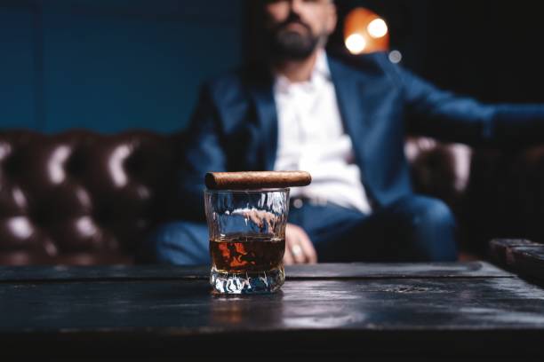 Glass of brandy and cuban cigar on an old wooden table. Glass of brandy and cuban cigar on an old wooden table cigar photos stock pictures, royalty-free photos & images